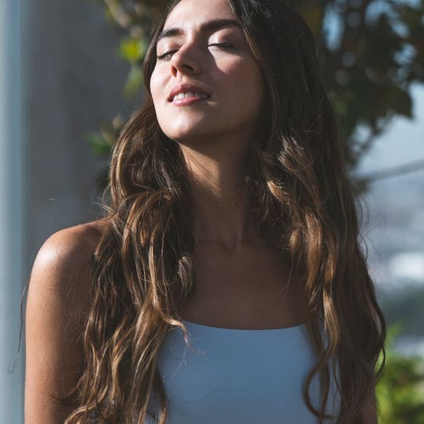 Smiling pregnant woman meditating with eyes closed.